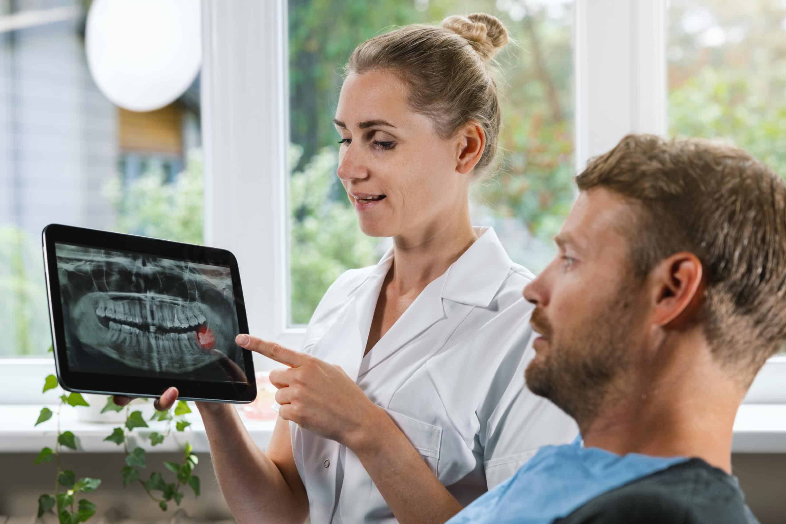 Dentist,Showing,And,Explaining,Dental,X-ray,Picture,With,Impacted,Wisdom teeth